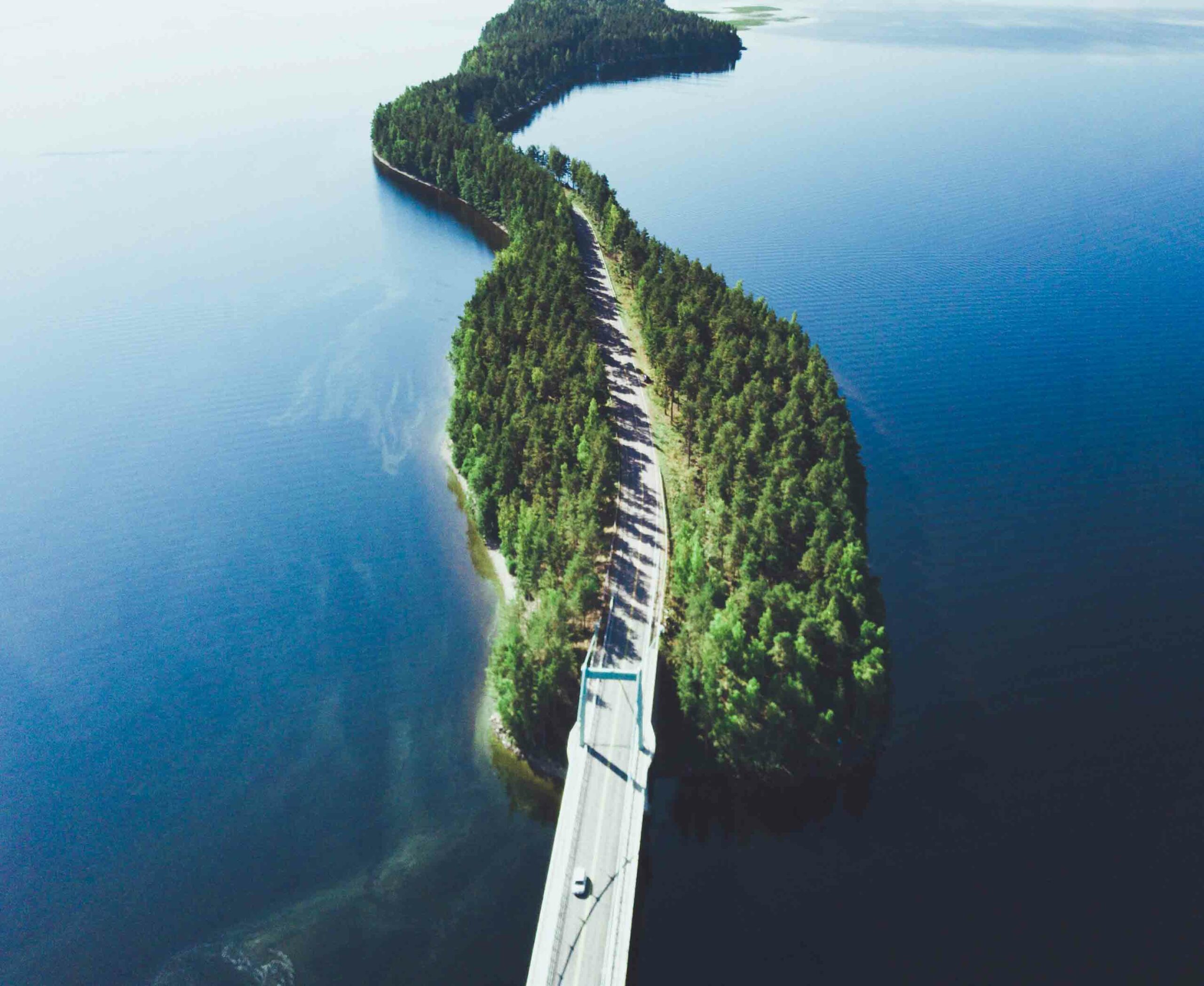 metsäinen maantie kulkee järvien välissä.